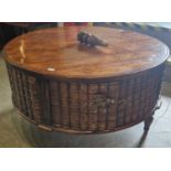 A modern mahogany and faux book circular shaped coffee table, the frieze with two pairs of