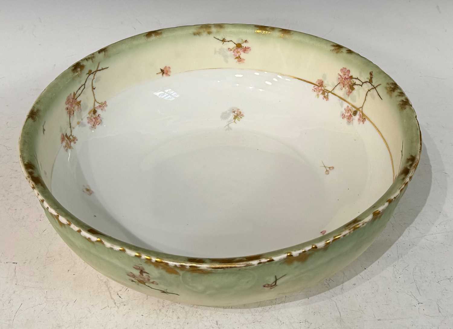 A large Limoges porcelain wash basin with hand-painted details of dog roses and gilded accents,