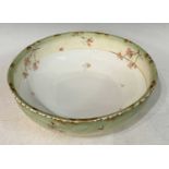 A large Limoges porcelain wash basin with hand-painted details of dog roses and gilded accents,