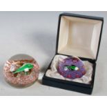 A vintage Paul Ysart style paperweight centred with a green fish on a purple ground with evenly