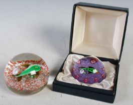 A vintage Paul Ysart style paperweight centred with a green fish on a purple ground with evenly