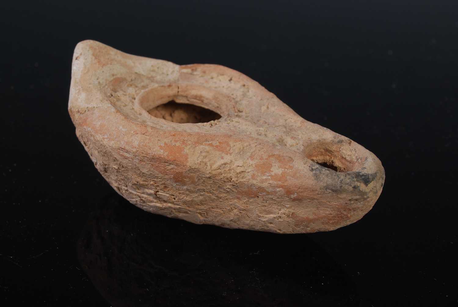 An antique pottery oil lamp, possibly Roman, 9cm long.