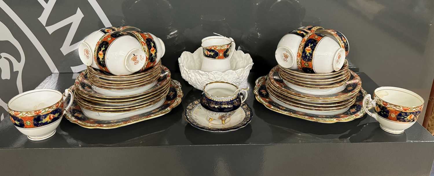 A Victorian hand painted part teaset with floral details within a red, navy and gilded border, the