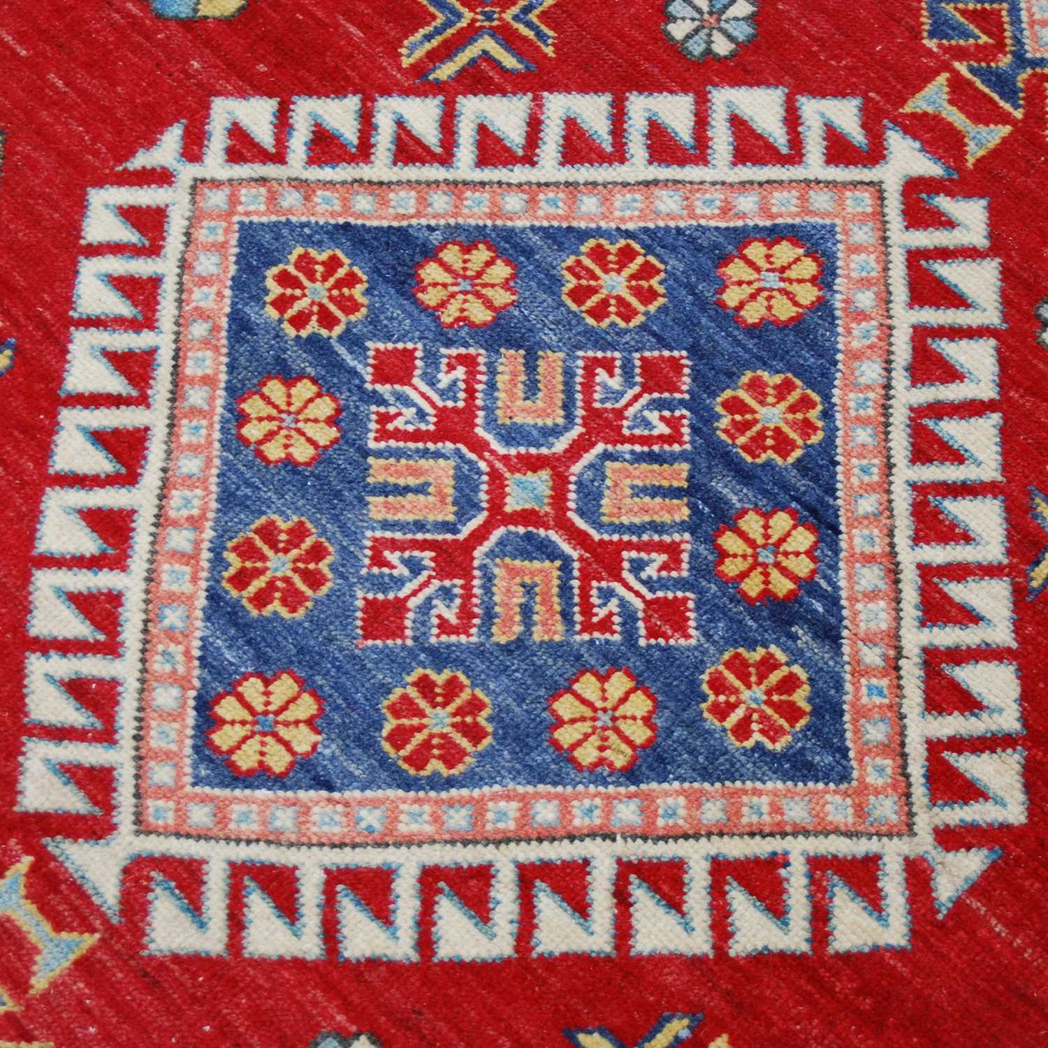 An Afghan Kazak rug, 20th century, the rectangular madder ground centred with a large blue ground - Image 4 of 5