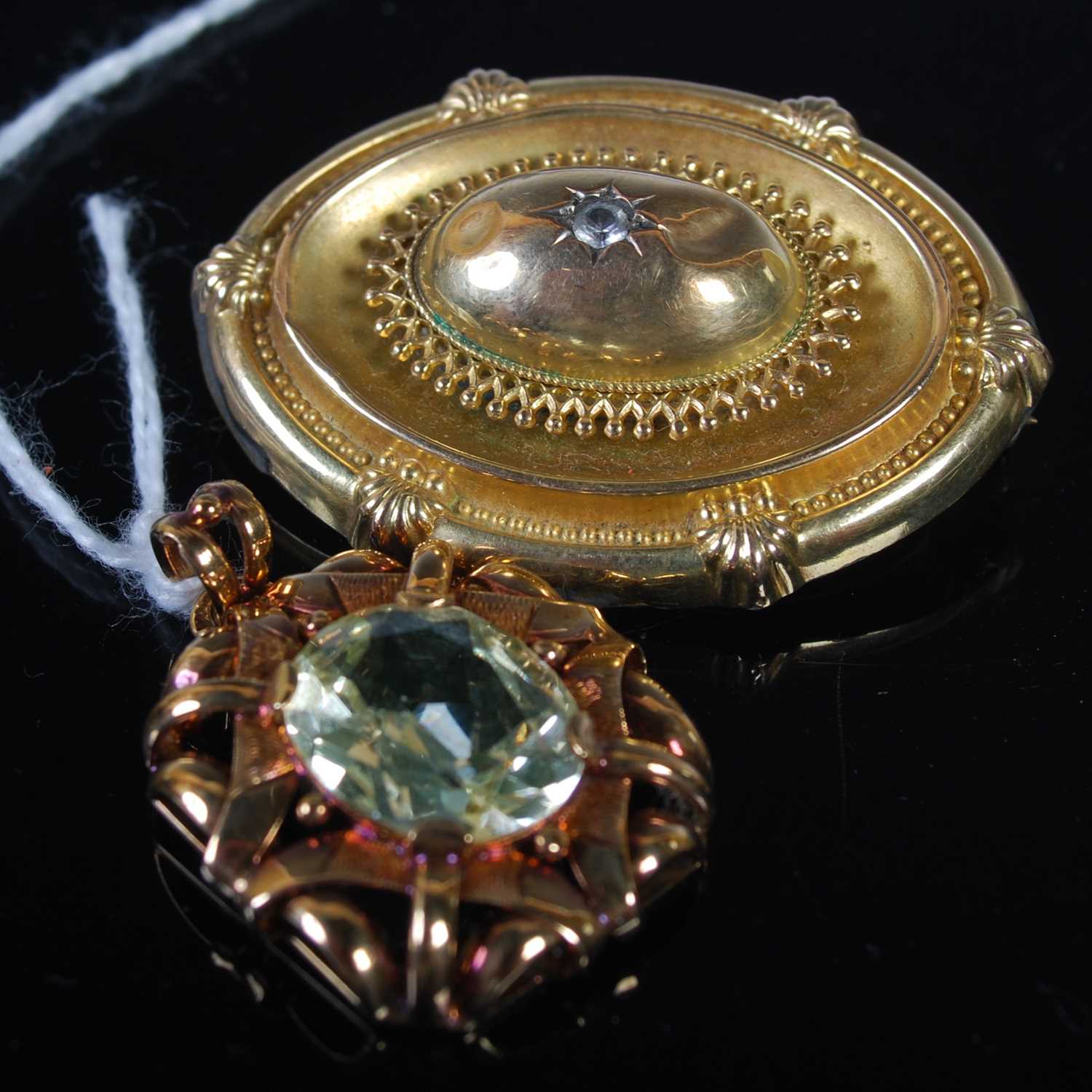 A yellow metal pendant set with pale peridot coloured oval faceted stone, together with a late