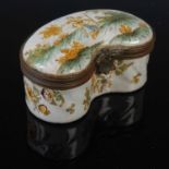 A 19th century Continental faience pottery kidney shaped box and cover, the hinged cover decorated