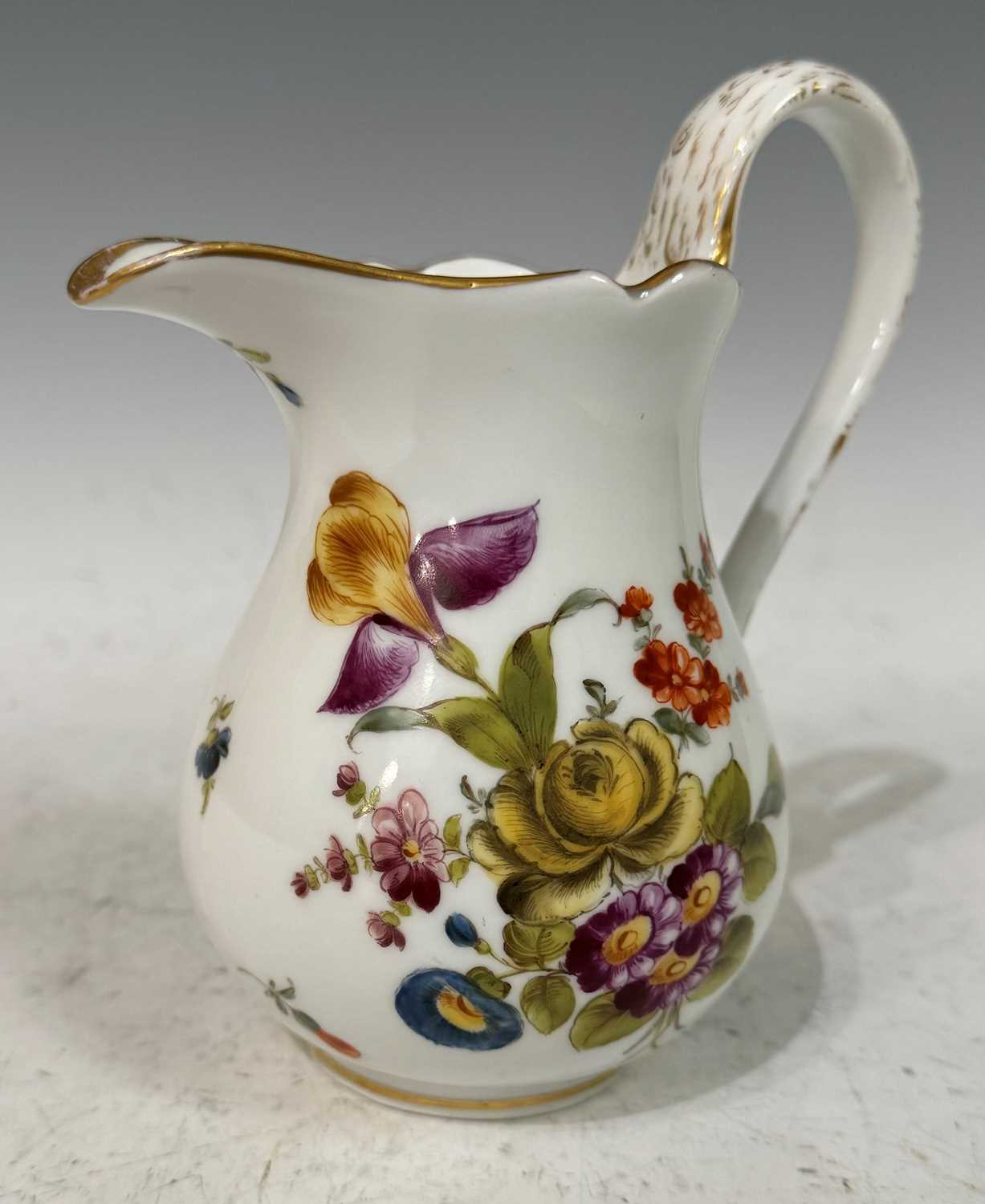 A mid-19th century Meissen style cream jug, with hand painted floral details and gilded accents,