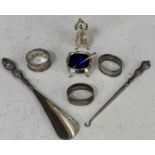 A collection of assorted silver to include three various napkin rings, pepper pot, mustard dish with
