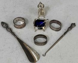 A collection of assorted silver to include three various napkin rings, pepper pot, mustard dish with