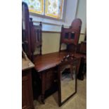 An Edwardian walnut dressing chest with two hinged mirror plates, two glazed cupboard doors, the