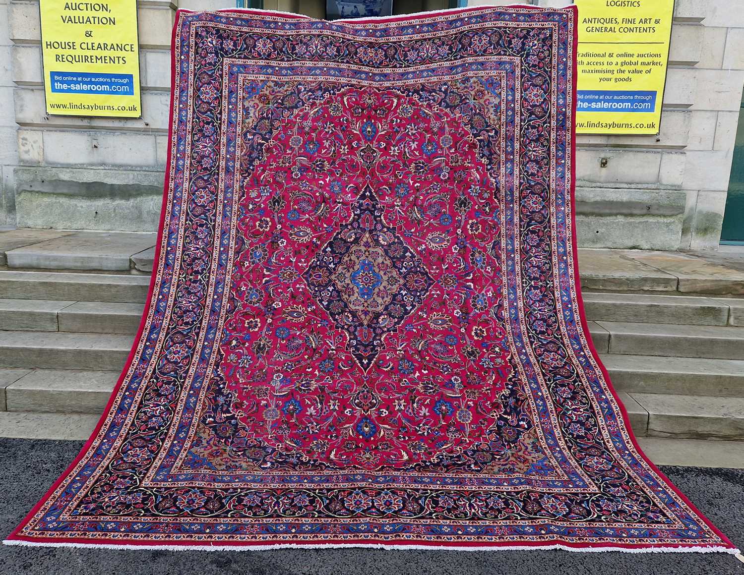A Persian Mashad carpet, 20th century, the rectangular magenta ground centred with a blue lozenge