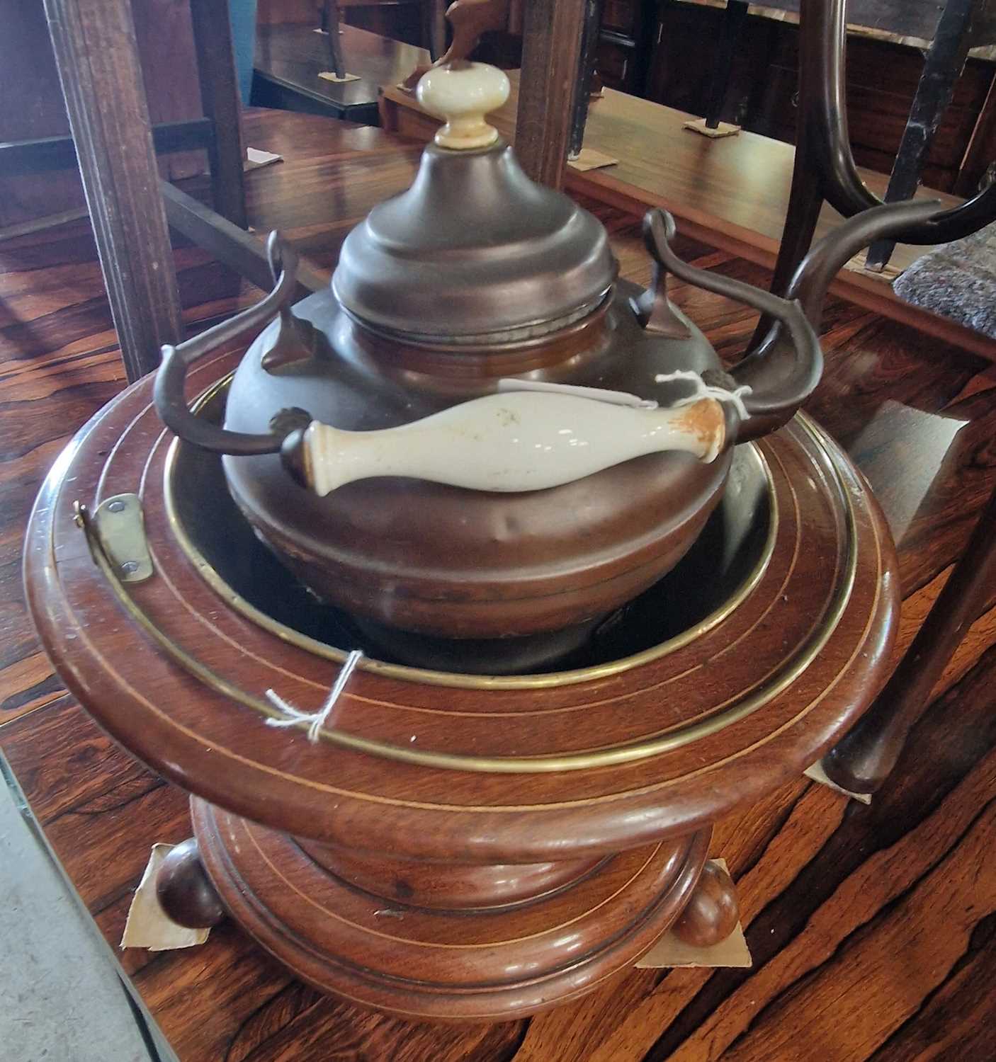 An antique Dutch mahogany tea-bucket with boxwood line detail raised on three circular feet,