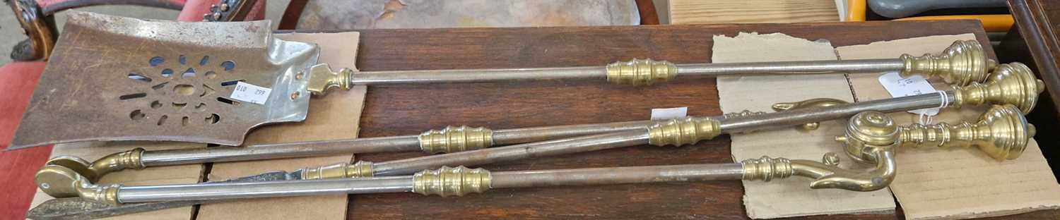 A set of three steel and brass fire irons, comprising poker, shovel and tongs, poker 72cm long.