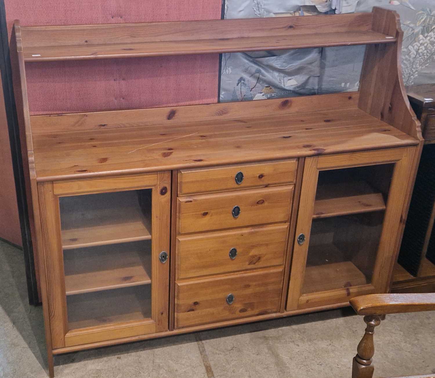 A pine sideboard fitted with a bank of four drawers and two glazed cupboard doors, 141cm wide.