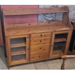 A pine sideboard fitted with a bank of four drawers and two glazed cupboard doors, 141cm wide.