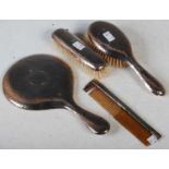 A Chester silver four piece dressing table set, comprising hand-held mirror, two brushes and a comb,