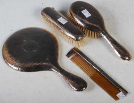 A Chester silver four piece dressing table set, comprising hand-held mirror, two brushes and a comb,
