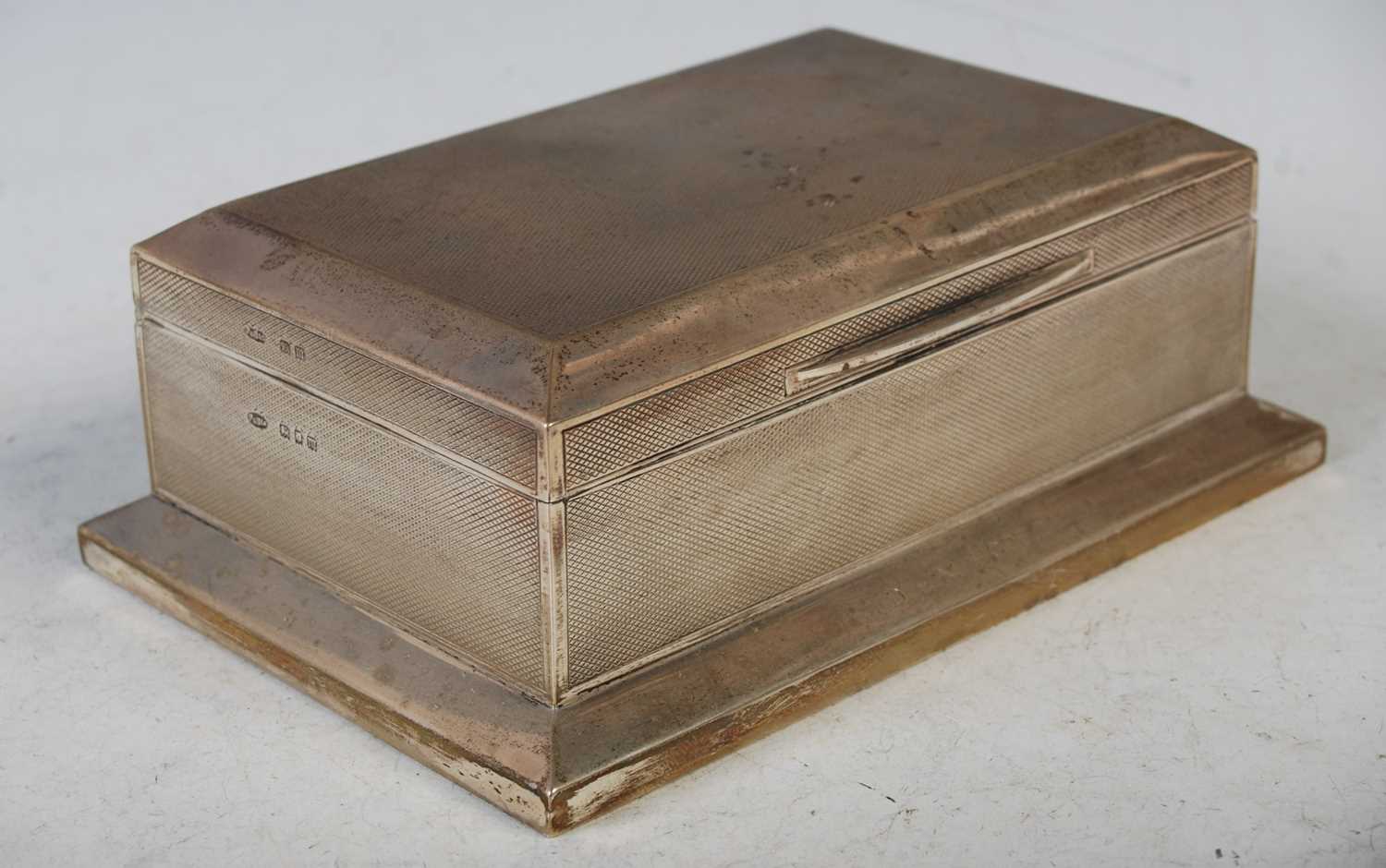 A George V silver cigarette box, London, 1927 with engine turned details bearing presentation