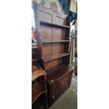 An antique mahogany waterfall bookcase, the upright back with three open shelves on a base fitted