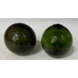 Fishing interest - Two antique green glass spherical fishing floats, 13cm high and 12cm high.