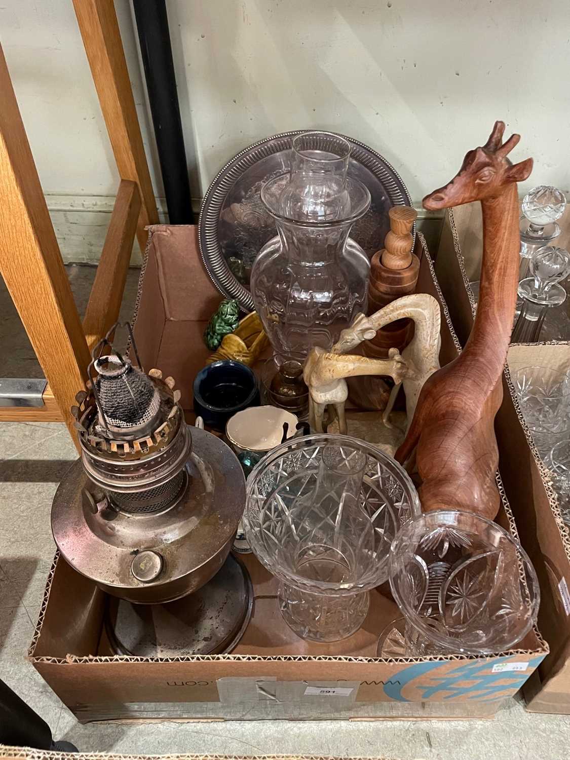 A box of mixed wares to include carved wooden animal figures, parafin lamp base, glassware etc.