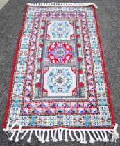 A Moroccan rug, 20th century, the rectangular field centred with a red ground octagonal shaped