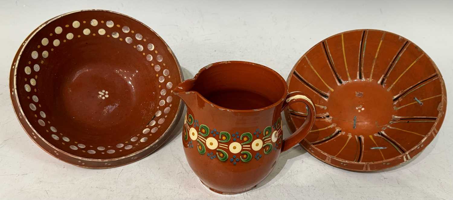 Three pieces of antique terracotta glazed clay pottery comprising a Kashubian style pottery jug