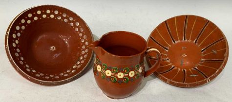 Three pieces of antique terracotta glazed clay pottery comprising a Kashubian style pottery jug