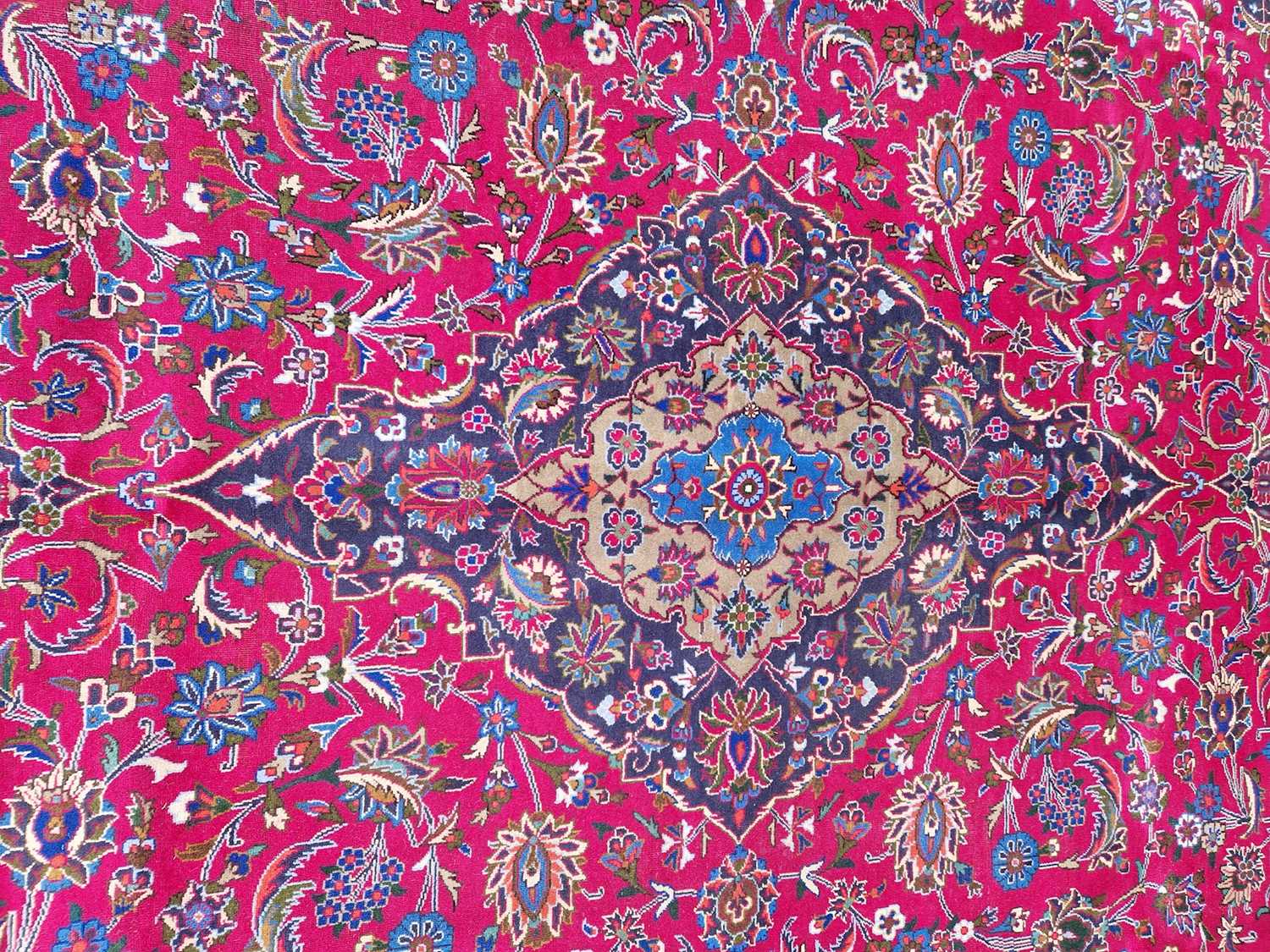 A Persian Mashad carpet, 20th century, the rectangular magenta ground centred with a blue lozenge - Image 4 of 5