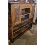 A late Victorian oak side cabinet fitted with one small drawer, two foliate carved cupboard doors