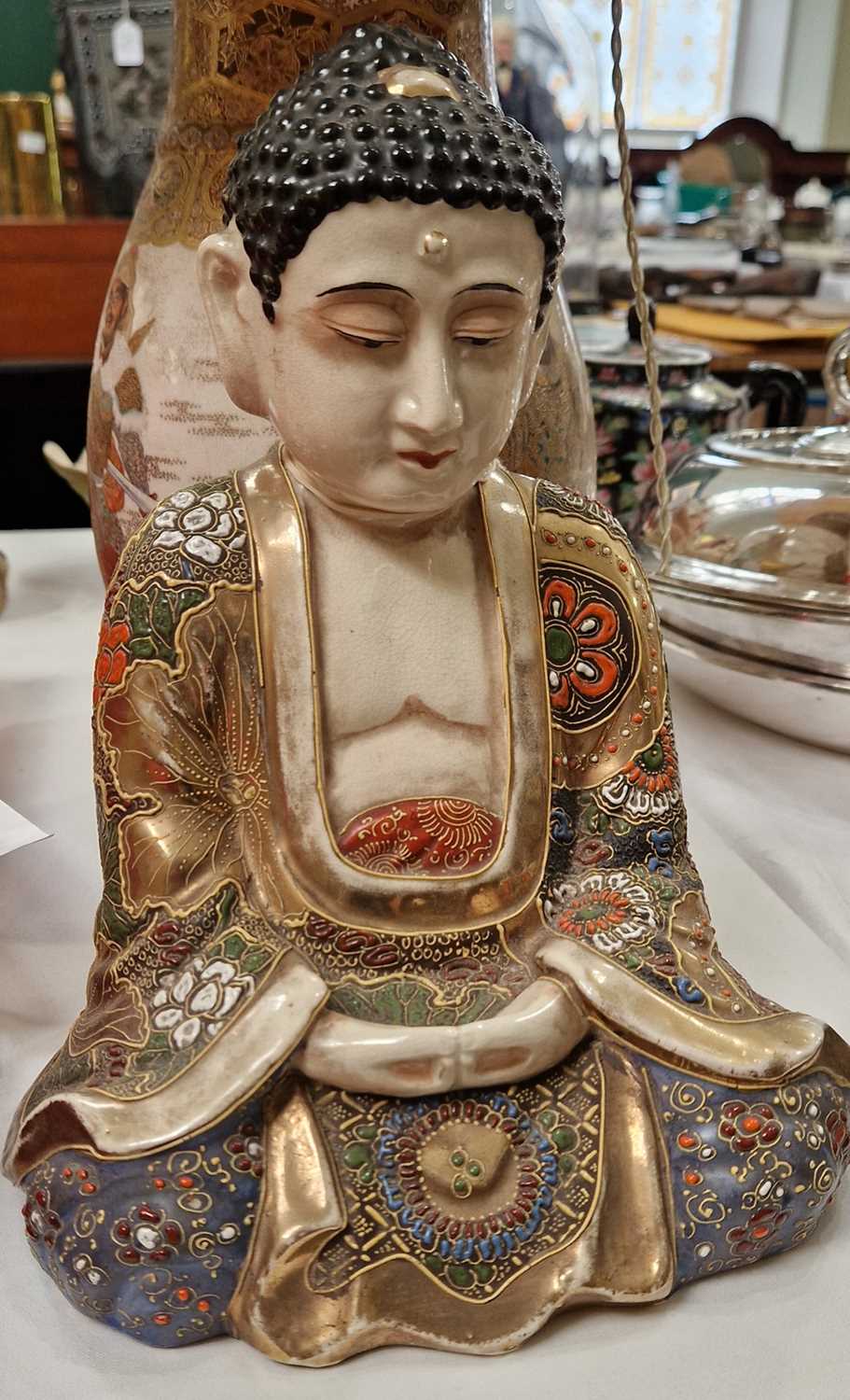 An early 20th century Japanese Satsuma buddha figure, the underside with painted marks, 24cm high.