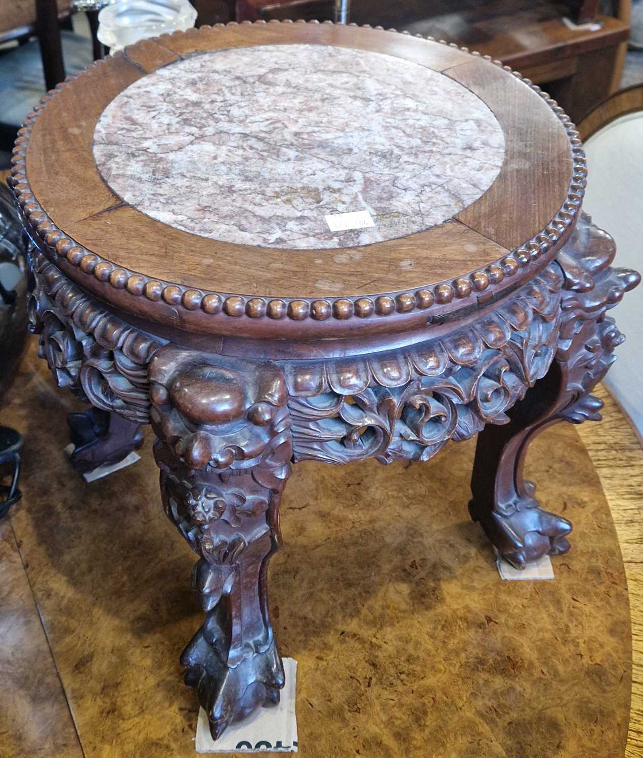 A Chinese darkwood jardiniere stand, the circular top with mottled red and white marble insert, 38cm