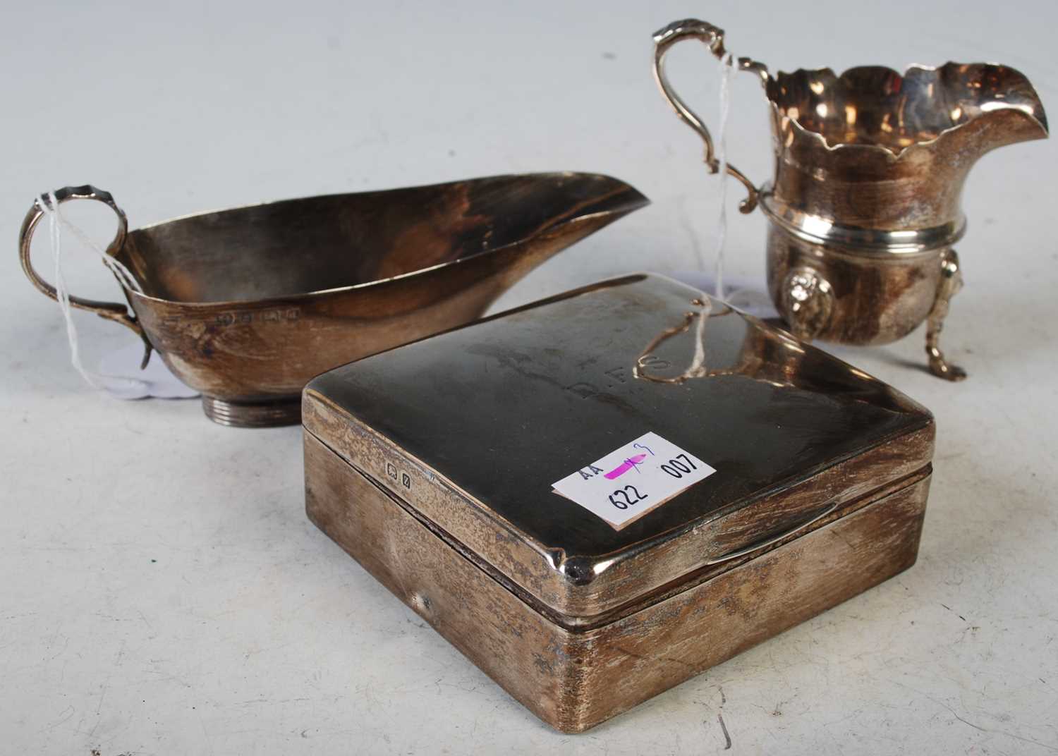 A collection of silver to include a Birmingham silver sauceboat, a Birmingham silver cream jug on
