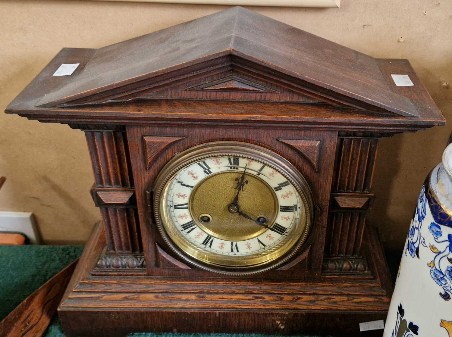 An early 20th century oak cased Architectural form mantle clock, with Roman numeral dial and twin