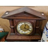 An early 20th century oak cased Architectural form mantle clock, with Roman numeral dial and twin