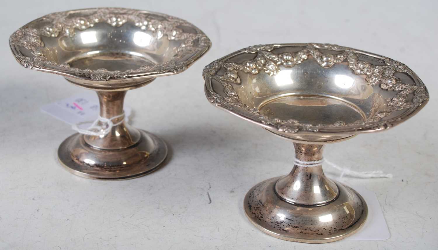 A pair of Birmingham silver pedestal bon bon dishes, embossed with floral garland around the rim,