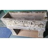 A composite stone garden planter, the rectangular planter moulded in relief with urn, fruit, flowers