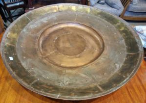 A large decorative copper wall plaque of circular form with rivetted detail, 90cm diameter.