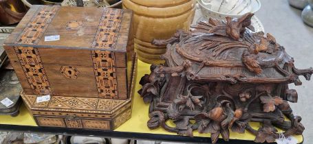 A late 19th century Black Forest carved wood casket, decorated in relief with flowers and birds,