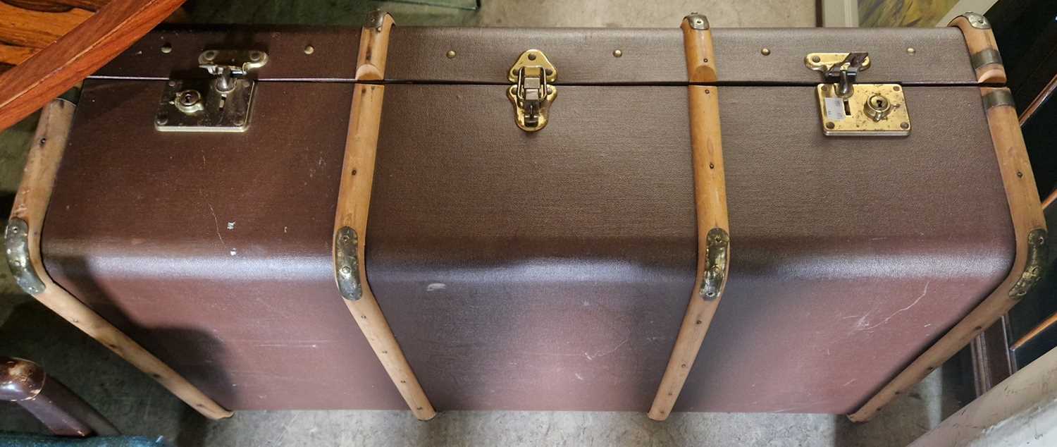 A vintage brown coloured cabin trunk with wood and brass bound detail.