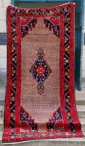 A Persian rug, 20th century, the rectangular cafe au lait coloured ground centred with a blue floral
