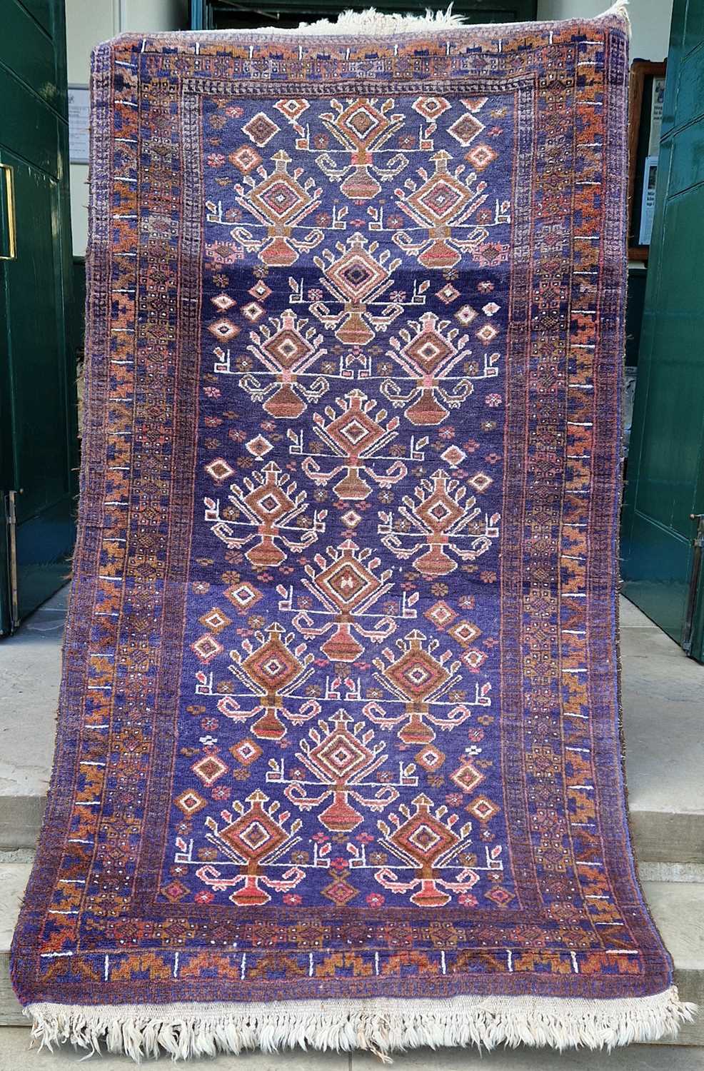 A Persian rug, 20th century, the blue ground decorated in white madder and ochre coloured threads