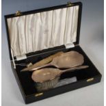 A cased Birmingham silver three piece dressing table set, comprising hand-held mirror, brush and
