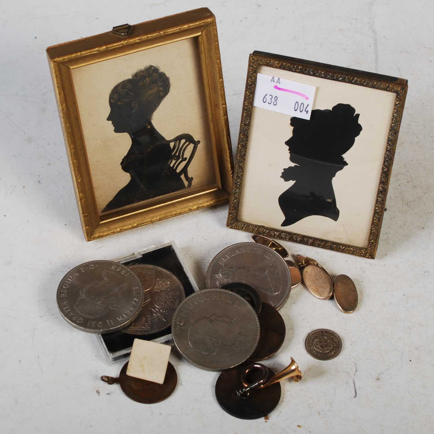 A collection of various items to include two small silhouette pictures, assorted coinage to