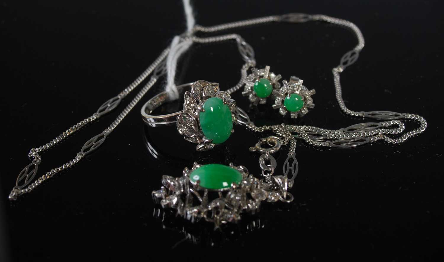 A suite of white metal green stone and paste set jewellery comprising pendant and chain, ring and