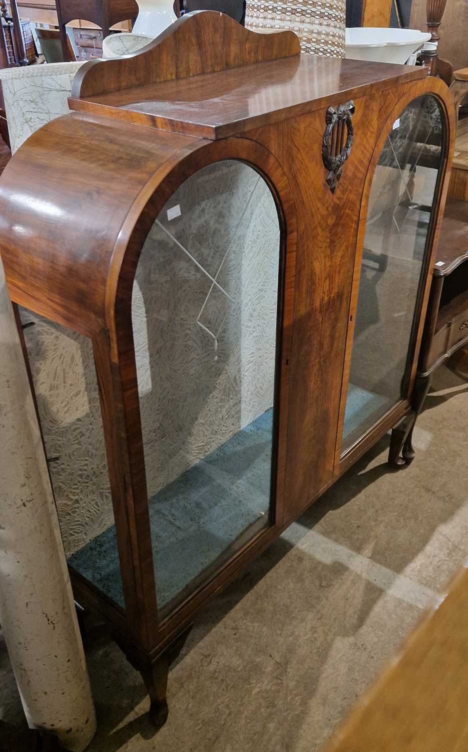 An early 20th century walnut display cabinet in the Art Deco style, with two glazed cupboard doors