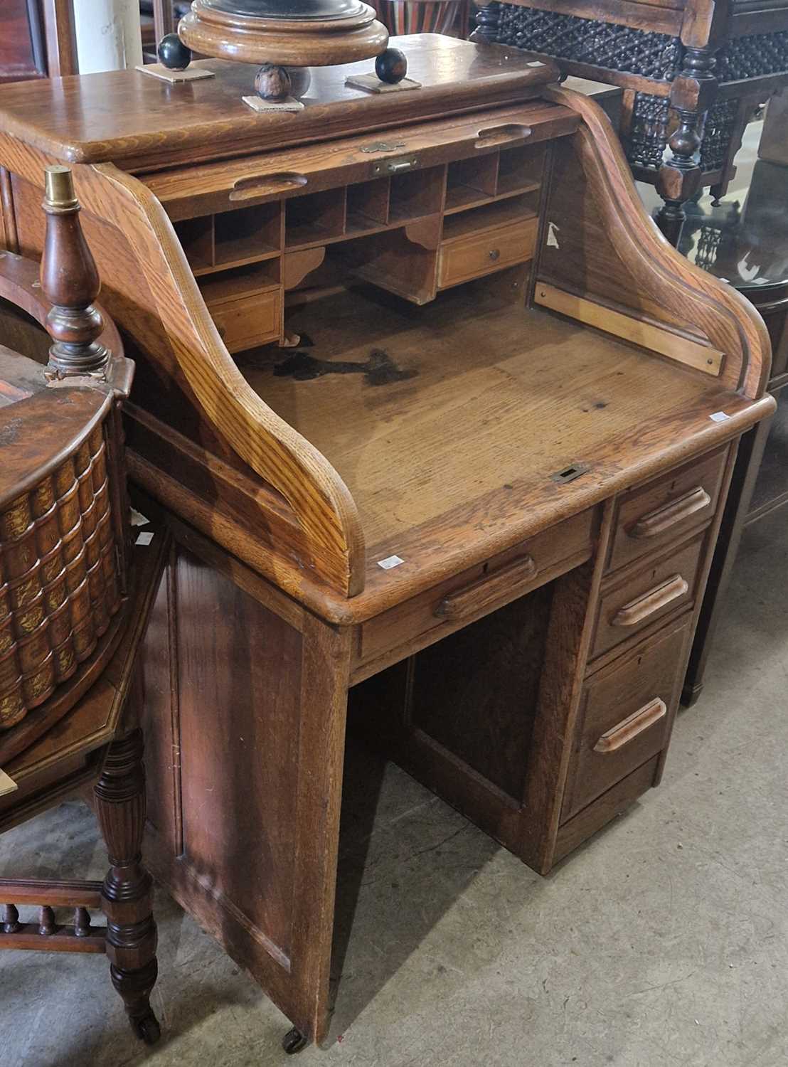 A vintage oak roll-top desk with serpentine tambour front, the lock plate inscribed 'Angus', 83cm