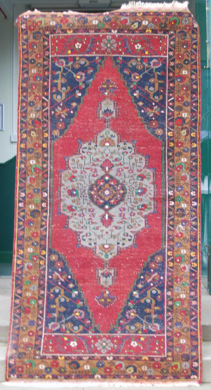 A Turkish long rug, 20th century, the rectangular abrashed madder ground centred with a large oval - Image 3 of 6
