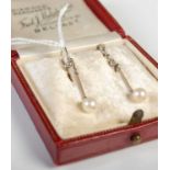 A pair of white metal and pearl drop earrings stamped 9ct, in red leather covered fitted box.