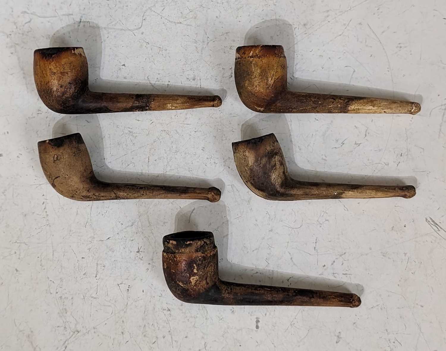 A collection of five assorted vintage clay pipes.